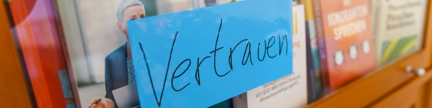 Nahaufnahme handgeschriebenen Aufklebers mit dem Wort Vertrauen auf einem Bücherschrank im im HCCI Health Care Coaching Institute für Coaching, Supervision und Organisationsentwicklung in Berlin-Charlottenburg