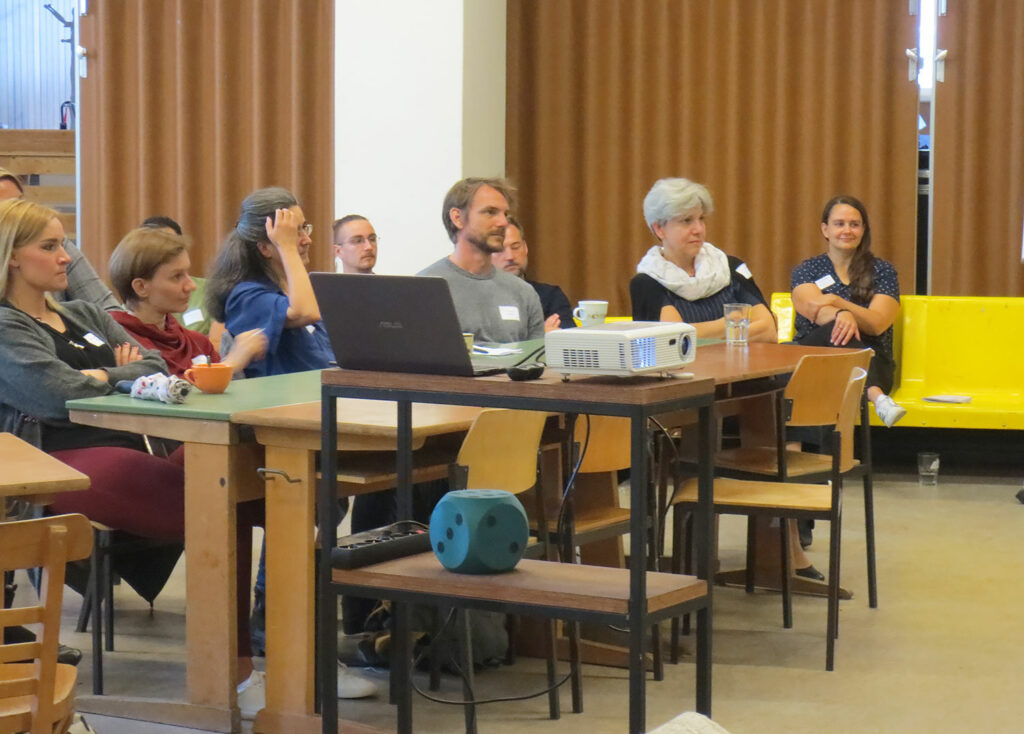 Gruppe von Teilnehmer:innen an Tischen sitzend beim Networking-Camp Science 1.0 des HCCI, Institut für Supervision in Berlin