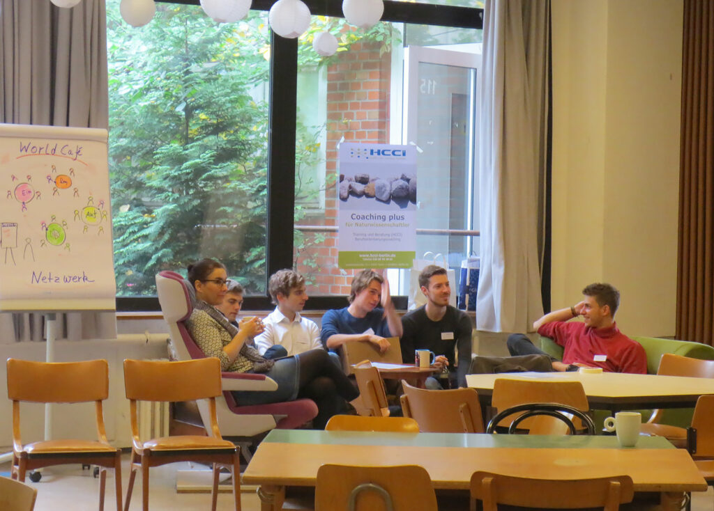 6 Teilnehmer:innen auf Sofa und Sesseln sitzend im Gespräch; Eindrücke vom Networking-Camp Science 1.0 des HCCI, Institut für Supervision in Berlin