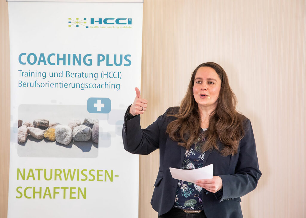 Frau hält Vortrag vor Plakat, Coaching Plus Naturwissenschaften, Eindrücke vom Networking-Camp Science 2.0 des HCCI, Institut für Supervision in Berlin